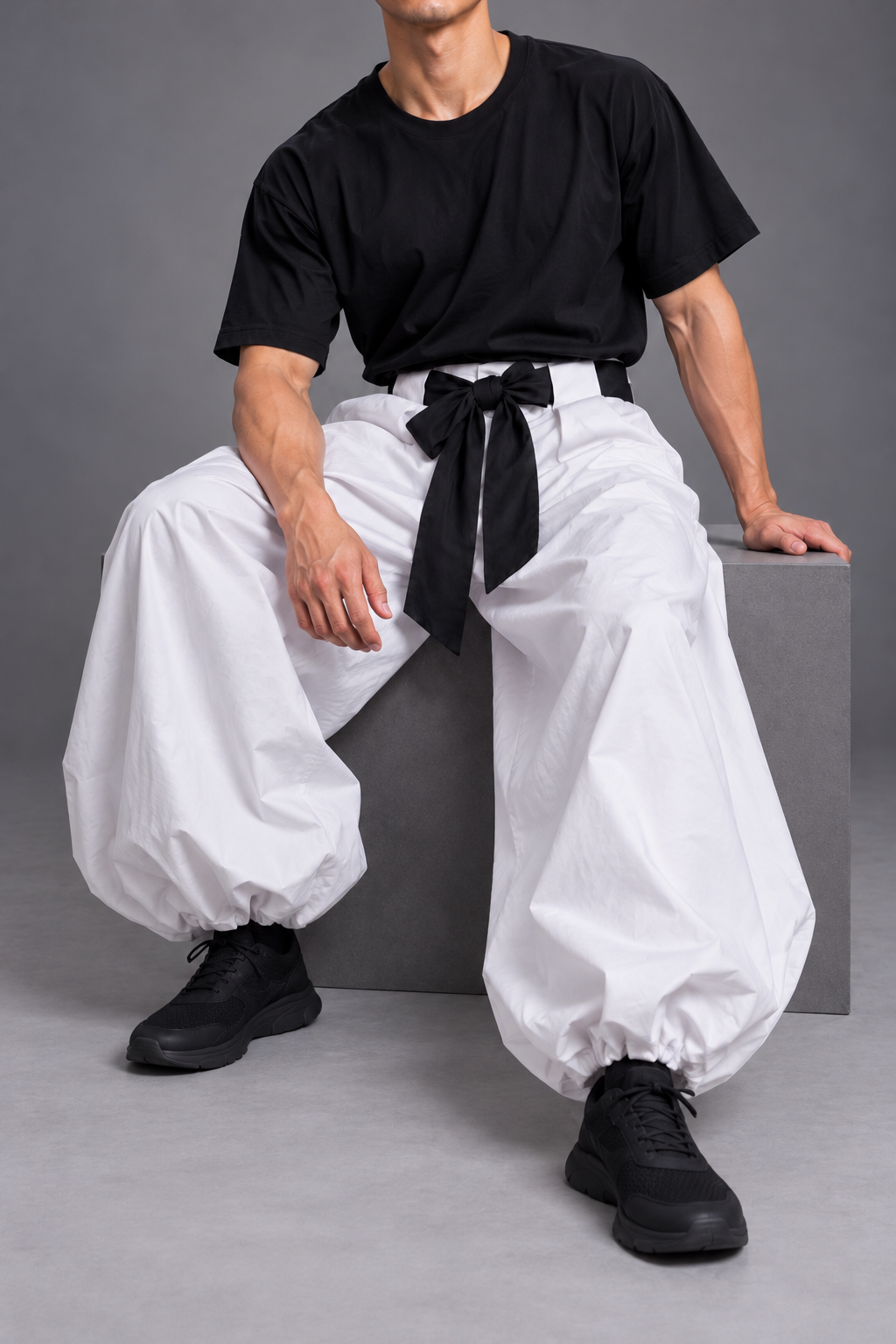 Toji cosplay seated pose with sash and gathered white trousers